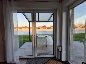 an open door to a patio with a view of the water at Seehaus Westufer in Walchum +17 photos