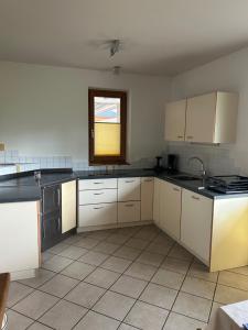 a large kitchen with white cabinets and a window at Apartment Welscher in Nova Levante