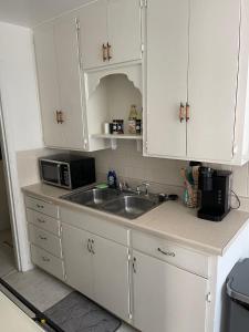 eine Küche mit Spüle und Mikrowelle in der Unterkunft Everything you need - 1 BR 1 BA WIFI SMART TV QN Bed Coffee in Wichita + 5 Fotos