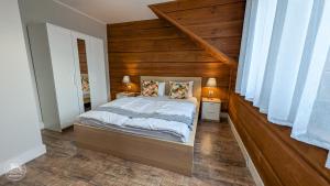 a bedroom with a bed with a wooden headboard at Przy Rozlewisku in Sarbinowo