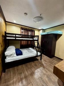 Un dormitorio con dos literas y suelo de madera. en Ezwi's Staycation, en Baguio