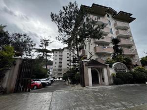 Un gran edificio con coches aparcados delante. en Ezwi's Staycation, en Baguio 1 foto más