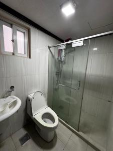 Un baño con ducha, inodoro y lavabo. en Ezwi's Staycation, en Baguio