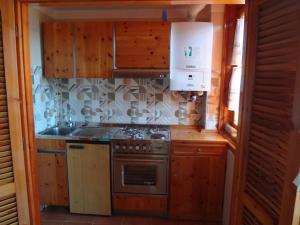 una cucina con mobili in legno e una stufa di La casetta di Rivisondoli a Rivisondoli Altre 25 foto