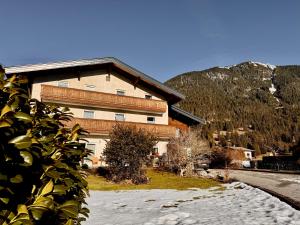a large building with snow in front of it at Haus Greif in Weissenbach am Lech