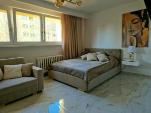a bedroom with a bed and a couch at Apartament Golden Rose in Kłodzko