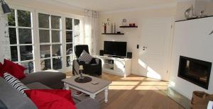 a living room with a couch and a tv at Ferienwohnung 1 Rosenberg 32 in Zingst