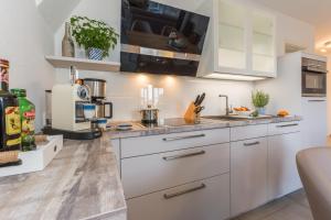 a kitchen with white cabinets and a sink at Victoria Luna Penthouse No 10 Strandstrstr48 in Zingst