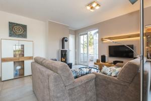 a living room with two couches and a tv at Victoria Luna Penthouse No 10 Strandstrstr48 in Zingst