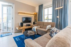 a living room with a couch and a tv at Victoria Luna Penthouse No 10 Strandstrstr48 in Zingst