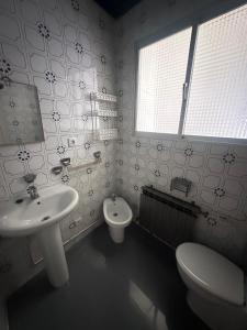 a bathroom with a sink and a toilet and a window at Casa Colón en la mancha in Herencia