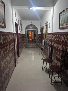a hallway with chairs and a table in a room at Casa Colón en la mancha in Herencia +3 photos