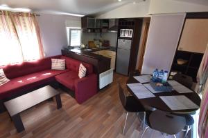 a living room with a red couch and a table at Casa natural con cenador en jardín y parking in San Vicente do Mar