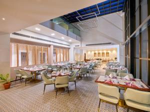 a large dining room with tables and chairs at Regenta Dwarka in Dwarka