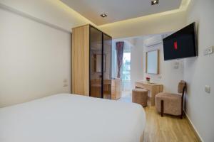 a bedroom with a white bed and a tv at The Platinum Pyramid view inn in Cairo