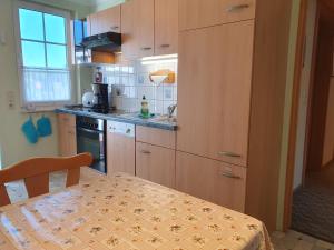 a kitchen with wooden cabinets and a table with a tablecloth at Ferienwohnung 2, oben in Bad Wilsnack