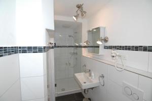 Un baño blanco con lavabo y espejo. en Mittelberg Ferienwohnung, en Mittelberg 6 fotos más