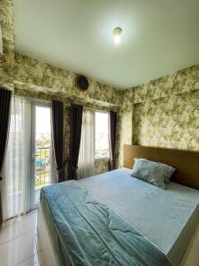 贝克西Apt Metropolitan Park Berkasi with Pool & Wifi by Damaresa的带一张大床和一扇窗户的卧室