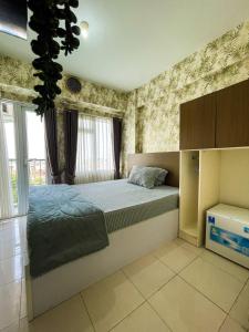 贝克西Apt Metropolitan Park Berkasi with Pool & Wifi by Damaresa的一间带床和大窗户的卧室