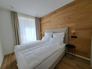 a white bed in a room with a wooden wall at Eck am Meer 2 in Eckernförde