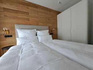 a white bed in a bedroom with a wooden wall at Eck am Meer 2 in Eckernförde +20 photos