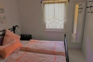 a bedroom with two beds and a window at Ferienbungalow Fleesensee in Malchow +4 photos