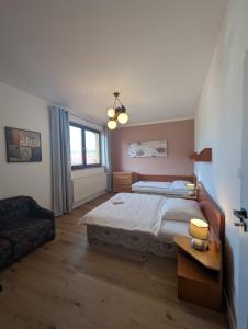 a bedroom with a large bed and a chair at Apartmany u Denyho in Zuberec