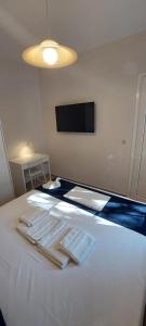 a bedroom with a white bed with towels on it at Kea's Living Yard II in Korissia +6 photos