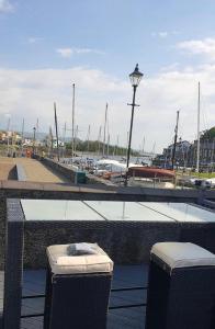 two trash cans sitting next to a marina with boats at lovely apartment porthmadog harbourside views of mountains festiniog railway in Porthmadog