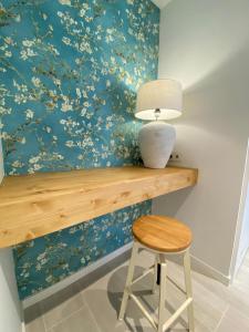a table with a vase and a stool in front of a wall at Rinconcito en el Paraíso Costa Ballena in Costa Ballena