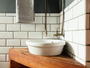 a white sink on a wooden table in a bathroom at Stone cottage in Haarties in Kalkheuvel +32 photos