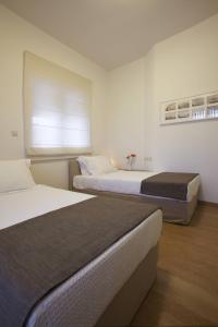 1 dormitorio con 2 camas y ventana. en Ikia Luxury Homes, en Gonia