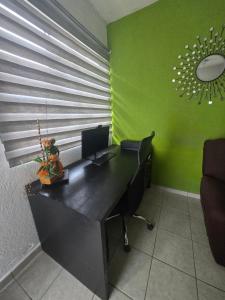 ein Büro mit einem Schreibtisch und einem Computer darauf in der Unterkunft Casa NK in Tierra Colorada