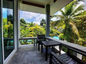 a porch with benches and a view of a pool at sengjan garden krabi in Ban Khlong Son