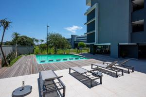 a patio with chairs and a swimming pool at 226 Millennial Umhlanga in Durban