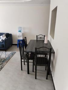 ナクルにあるKings Sapphire Apartments,Nakuruの黒いダイニングルーム(リビングルーム内のテーブルと椅子付) +11枚の写真