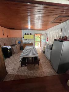 a kitchen with a table in the middle of it at Casa Tangerina - Lago Pinhal in Rio dos Cedros +20 photos