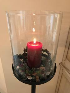 a candle in a glass container with rocks and a candle at Godeke Michels Ferienwohnung 21 Seestr5b in Groß Kirr