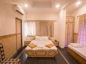 a bedroom with a bed and a chair in it at Hotel Suriya International in Chennai +13 photos