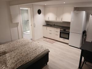 a kitchen with a bed and a white refrigerator at studio apartment 24 sqm in Trondheim +1 photo