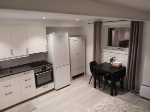 a kitchen with a table and a refrigerator and a table and chairs at studio apartment 24 sqm in Trondheim