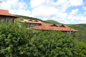 a house with a red roof on top of a hill at Flat no Condominio Monte Castelo Gravatá in Sairé