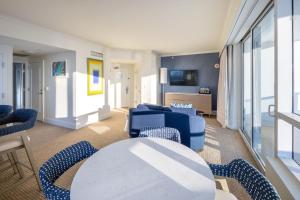 a living room with blue chairs and a table at Fontainebleau Hotel Ocean View Fits 6! 1 BED/2 BA in Miami Beach