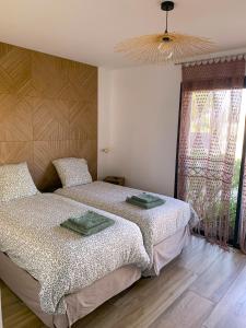 a bedroom with two beds and a window at pontons view residence in Saint-Côme-de-Fresné