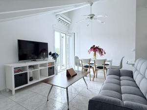 a living room with a couch and a tv and a table at Angel Apartment in Fiskardo