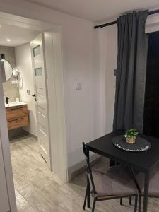 a room with a table and a bathroom with a sink at Apartamenty ARIA in Świnoujście