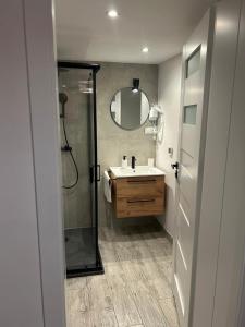 a bathroom with a shower and a sink and a mirror at Apartamenty ARIA in Świnoujście +53 photos