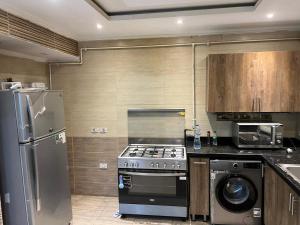 uma cozinha com fogão e geladeira em Duplex for rent in Choueifat, Fifth Settlement em Cairo