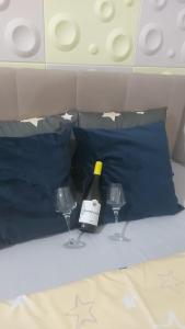 una bottiglia di vino e due bicchieri di vino su un letto di Cozy Max Studio a Jagodina