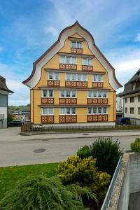 a large yellow building with a pointed roof at Blattenheimat - im traditionellen Appenzeller Haus in Appenzell